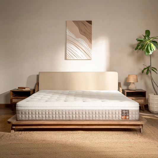 Mattress on a wooden bed frame in a bedroom setting with decor elements.